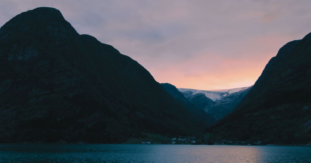 Gün batımında Norveç fiyortları ve dağlar